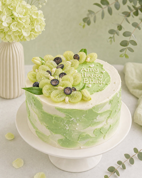 Close-up of textured green ombré buttercream finish with fresh fruit topping on cake