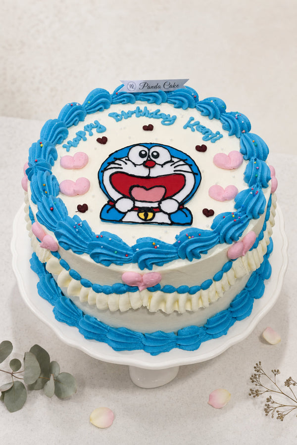 Round white frosted cake with bright blue buttercream rosettes and pink heart decorations on top