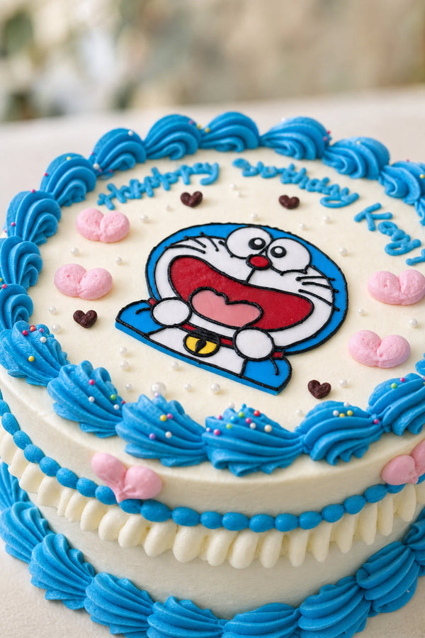 Top view of round white cake decorated with blue buttercream piping and pink hearts