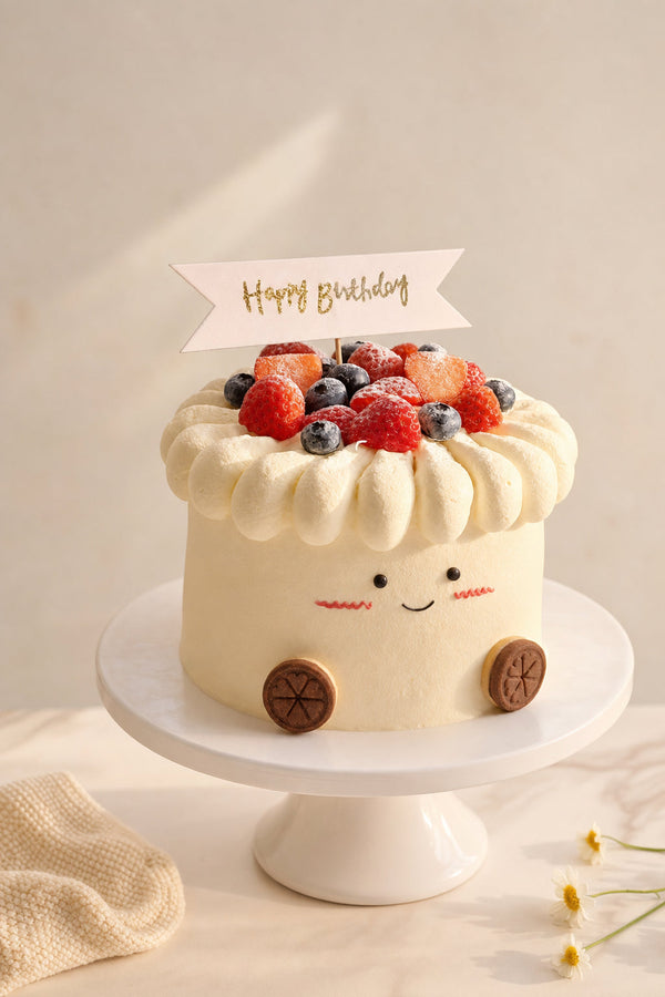 Studio photo of a round cream cake with piped white frosting ruffles, topped with fresh strawberries and blueberries, decorated with a small smiling face.
