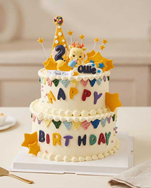 Two-tier white birthday cake with smooth creamy frosting, colorful fondant bunting, bold letter toppers spelling Happy Birthday, and playful edible decorations on top