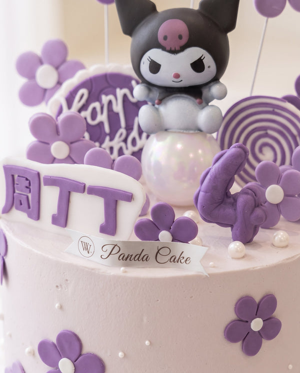Close-up of a two-tier pale pink cake with purple floral decorations, pearl accents, and Kuromi character on top